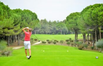 Man in red top playing golf Round Rock Golf